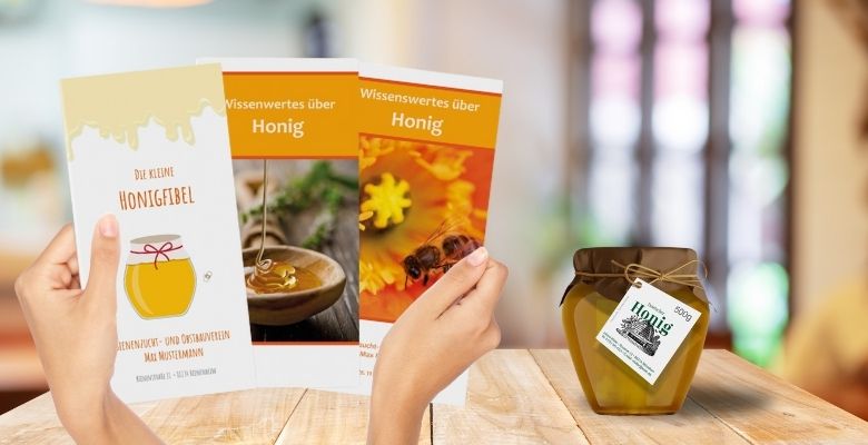 Verschiedene Honigflyer (in der Gr&ouml;&szlig;e DIN lang) liegen in 2 H&auml;nden