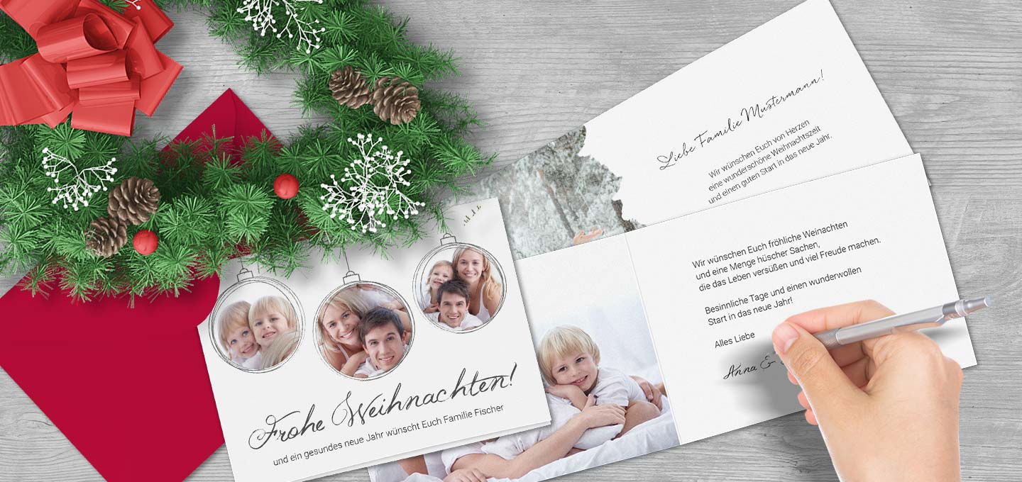 Weihnachtliche Gru&szlig;karten auf einem geschm&uuml;ckten Holztisch