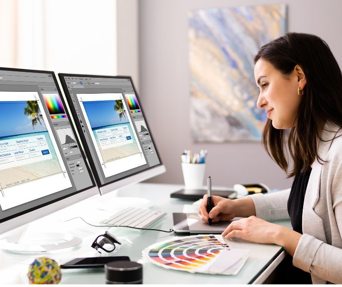 Grafiker vor zwei Bilderschirmen gestaltet ein Etikett.